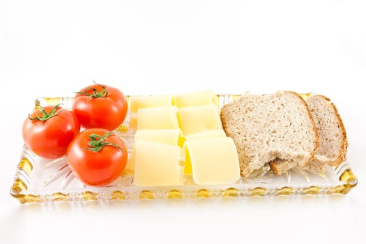 Picture of tomatoes, cheese, and some bread on a glass plate.
