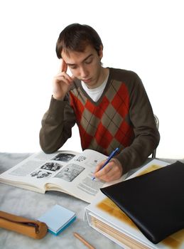 Male student at a table, holding head