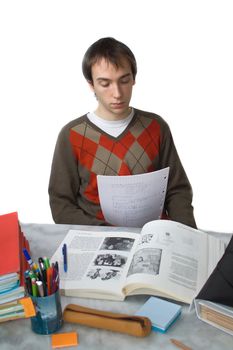Male student at a table, reading notes