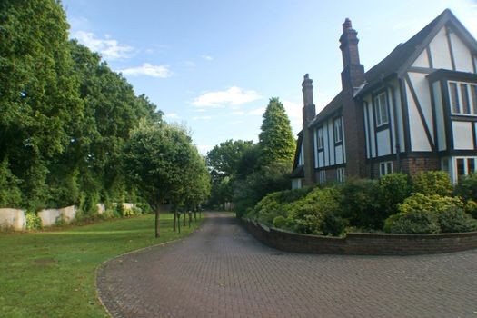 A driveway to a big tudor house in the UK.