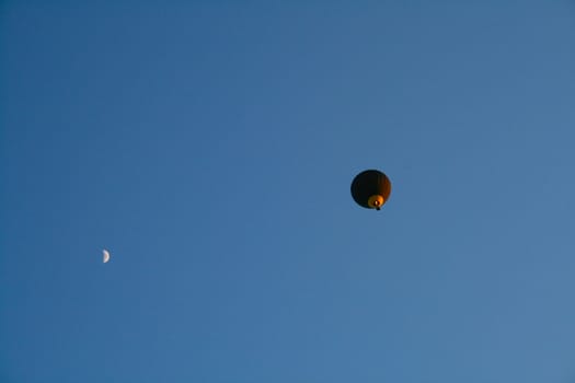 Balloon and moon on a background of pure blue sky