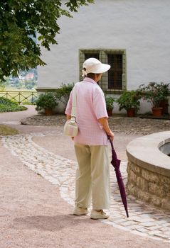 An elderly woman with an umbrella to walk