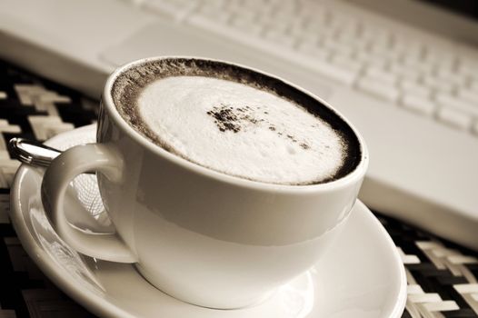 cappuccino and laptop in toned monochrome 