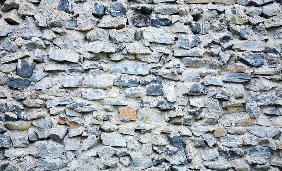Ancient grunge rough stone wall of a building
