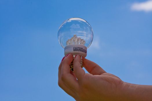 female teen holding a led light bulb up with a cloudy blue sky