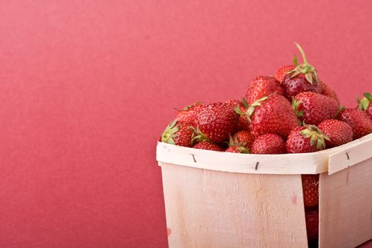 wooden quart of ripe strawberries on a solid background