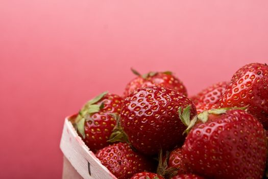 wooden quart of ripe strawberries on a solid background