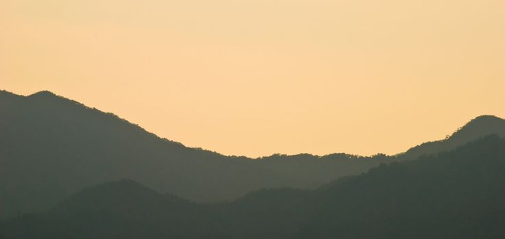 Panorama with golden sky and misty mountains at sunset in Japan