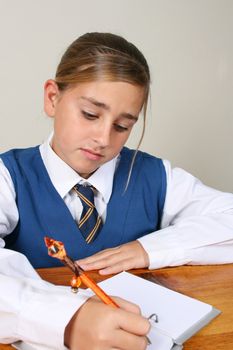 Teenage School girl busy with her homework, wearing uniform