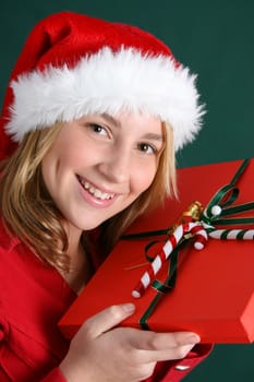Teenager wearing a christmas hat, holding a present
