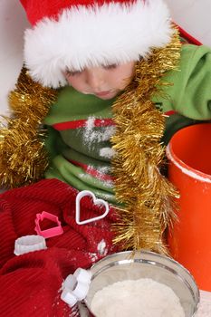 Toddler wearing a christmas hat, baking christmas cookies