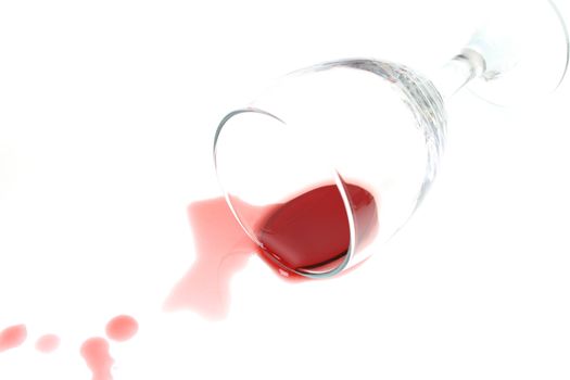 Knocked over wine glass with red wine spill