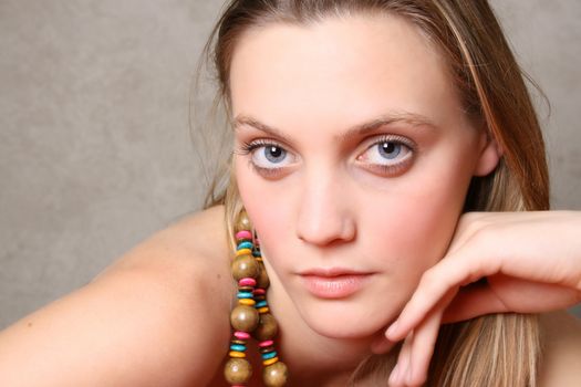 Beautiful female model with blue eyes and a string beads