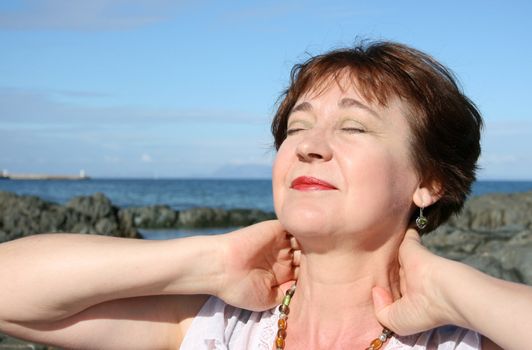 Beautiful mature brunette female on the beach