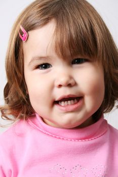 Toddler girl with chubby cheeks wearing a pink top