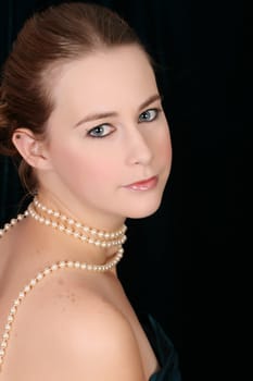 Beautiful female wrapped in fabric, wearing pearls