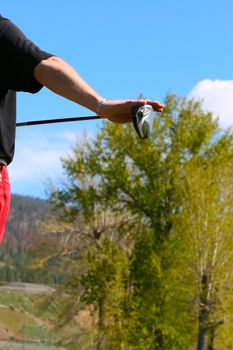 View of young golfer holding his driver preparing for a shot