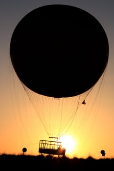 a passenger, helium balloon taking off at sunset