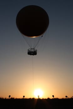 a passenger balloon taking off at sunset