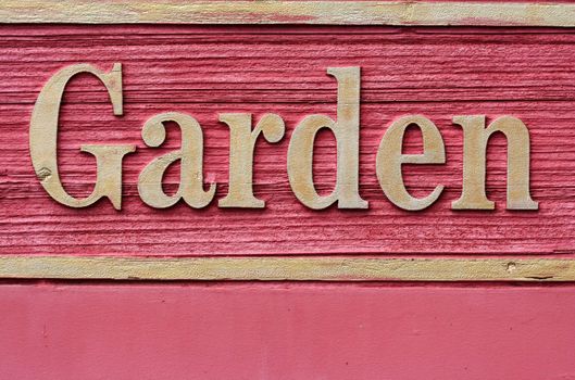 A Red wooded garden sign