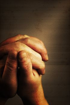 Prayers hands and sunbeam on old nostalgic background