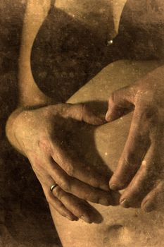 Two hands of a pregnant woman touching her skin retro