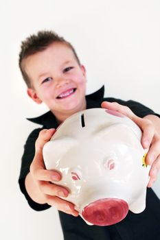 little boy is holding his piggy bank