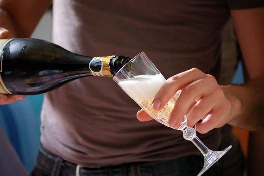 A man is serving champagne in a crystal glass