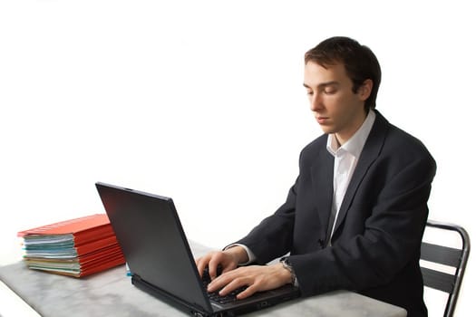 Young man works on laptop, side view, isolated over white