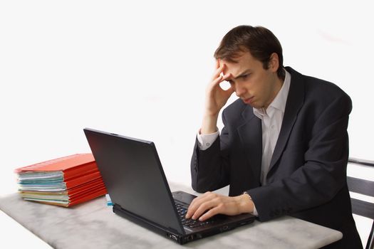Young man works on laptop, worried, isolated over white