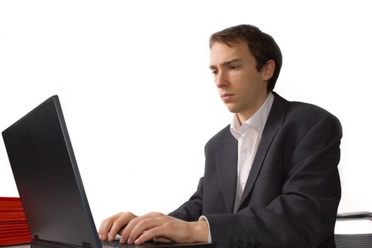 Concentrated young man works on laptop, isolated over white