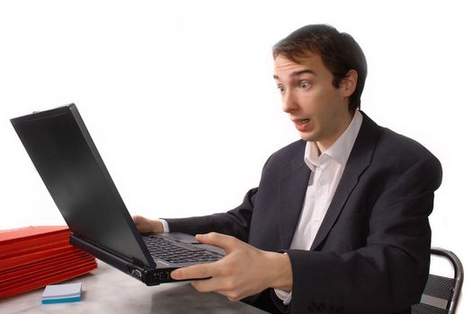 Young man freaks out in front of laptop, isolated over white