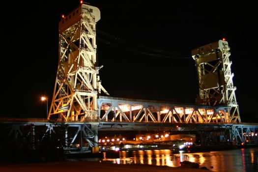 This is the draw bridge that links Houghton and Hancock Michigan across the Sturgeon River that leads into Lake Superior in the upper peninsula of Michigan taken at night from the Hancock side of the river.