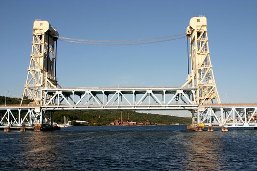 This is the draw bridge that links Houghton and Hancock Michigan across the Sturgeon River that leads into Lake Superior in the upper peninsula of Michigan taken during the day from the back of a boat on the river.