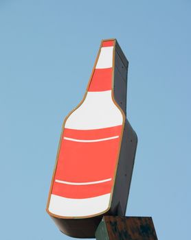 This is a vintage sign for a package liquor, party store, isolated against the blue sky.