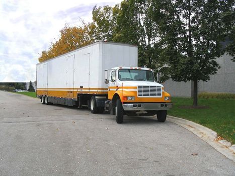 This is a picture of a moving van at an office building, ready to pick up furniture.