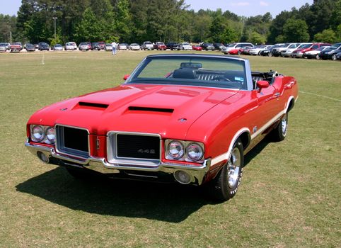 This is an early 1970s red olds 442 convertable mussle car taken at a car show.
