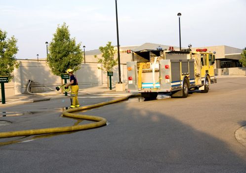 This is a fire department pumper truck emergency vehicle and a fireman working at a fire scene.