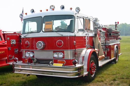 This is a picture of an old red fire engine taken at a classic truck show.