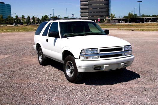 Small sport utility vehicle in a city setting with large office buildings in the background.