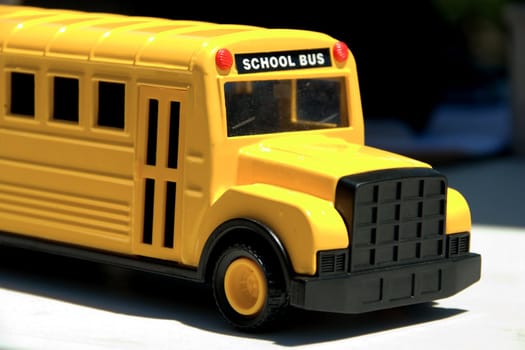 This is a picture of a toy school bus shoing the front end and entrance door.