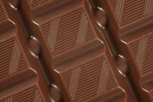 A macro photo of a large bar of milk chocolate as a background.
