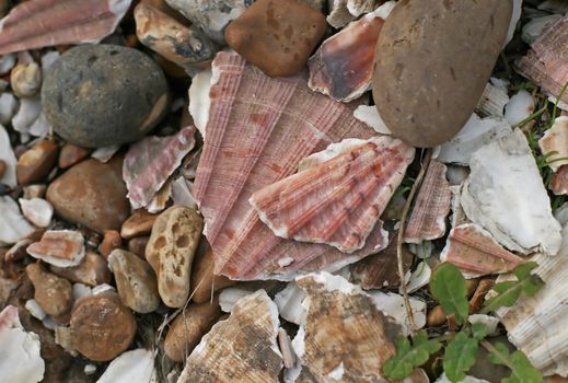 Natural arrangement of pebbles and stones on beach. One pebble shaped and marked to resemble Edvard Munch's painting The Scream.