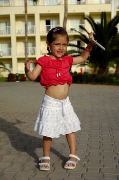 Young happy child is holding a hotel key