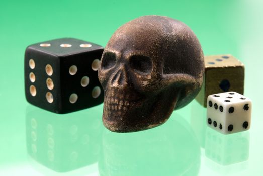 	
wooden skull and dice lie on a green background
