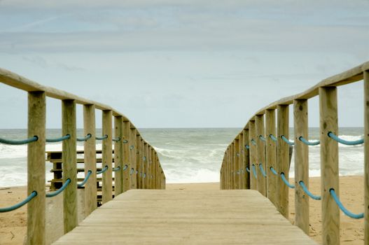 Wood access to empty beach in stormy day