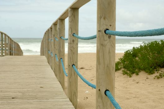 Wood access to empty beach in stormy day