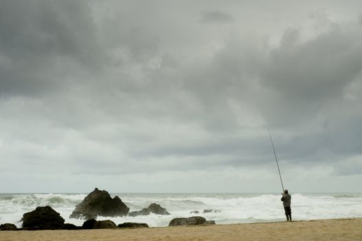 Man fising nearby stormy beacj