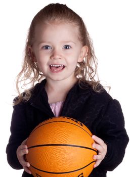 A cute girl is looking at the viewer asking if they want to play basketball.  She is very excited.