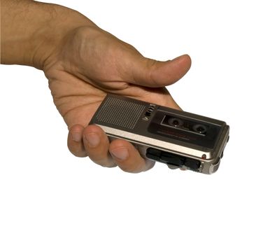 A male hand holding a microcassette recorder